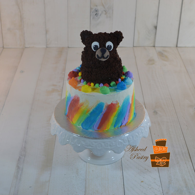 Birthday cake with a teddy bear on top,